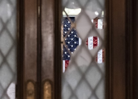 Broken glass from last week's confrontation with a pro-Trump mob is seen in the door to the House chamber at the Capitol in Washington, Tuesday, Jan. 12, 2021. House Speaker Nancy Pelosi, D-Calif ...