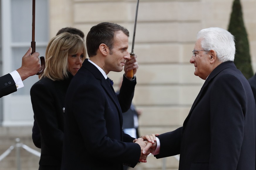 French President Emmanuel Macron welcomes Italian President Sergio Mattarella in the courtyard of the Elysee Palace Sunday, Nov. 11, 2018 in Paris. International leaders are taking place in a ceremony ...