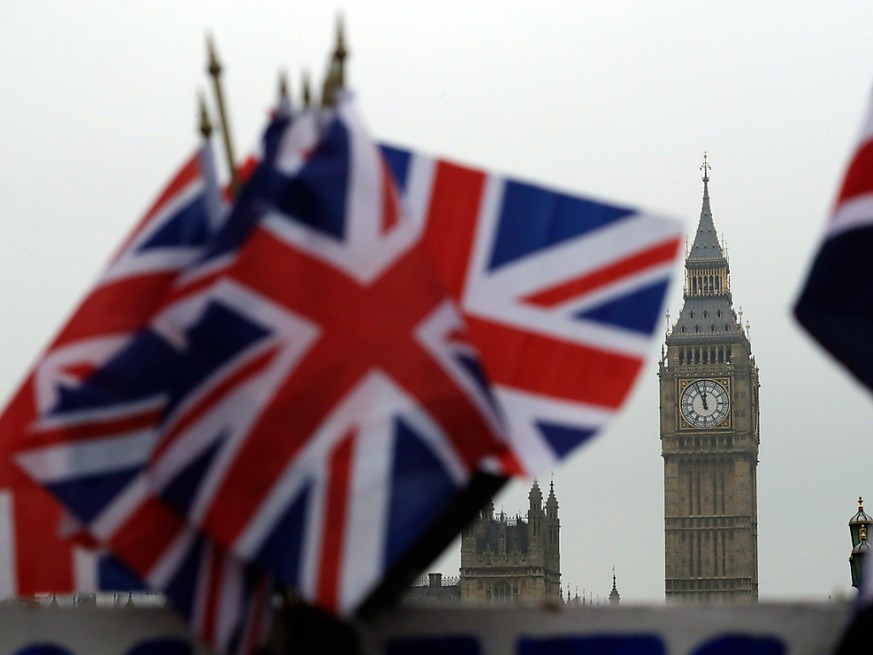 ARCHIV - Britische Flaggen wehen in der Nähe des berühmten Uhrturms Big Ben. Die Unterhändler beraten immer noch über den Brexit-Handelspakt. Foto: Matt Dunham/AP/dpa