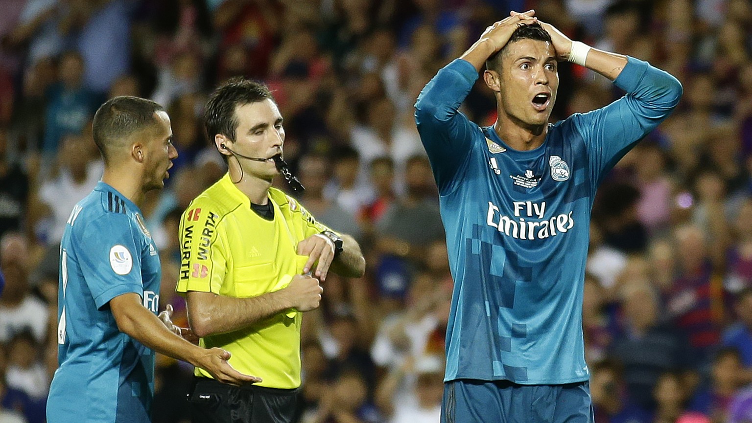 Real Madrid&#039;s Cristiano Ronaldo, right, reacts after Referee Ricardo de Burgos shows a yellow card during the Spanish Supercup, first leg, soccer match between FC Barcelona and Real Madrid at the ...