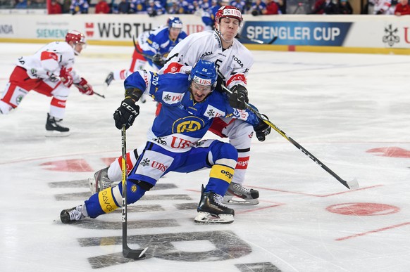 Davos Dino Wieser, left, fights for the puck against Yekaterinburgs Yegor Zhuravl, right, during the game between Switzerlands HC Davos and Avtomobilist Yekaterinburg at the 90th Spengler Cup ice hock ...