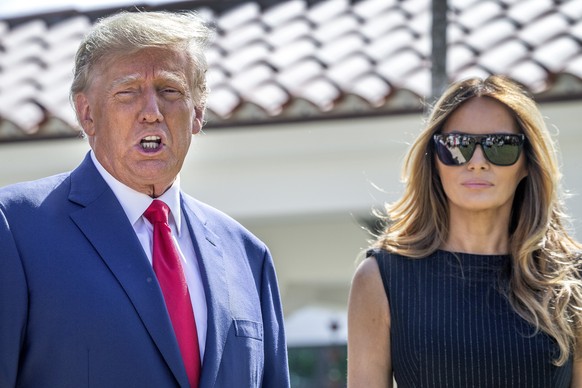 epa10294160 Former US President Donald J. Trump (L) and former First Lady Melania Trump (R), walk out of the electoral precinct after voting in-person at the Morton and Barbara Mandel Recreation Cente ...