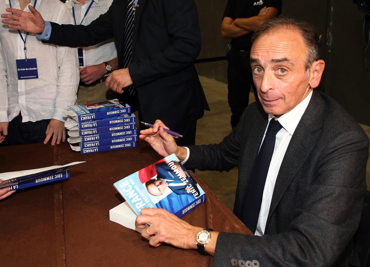 Hard-right political talk-show star Eric Zemmour dedicates his book in Biarritz, southwestern France, Tuesday, Oct. 26, 2021.Provocative anti-immigration commentator Eric Zemmour is drawing national a ...