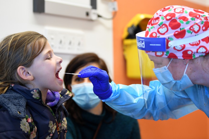 epa08602218 Healthcare worker Carmen Kennett (R) conducts a COVID-19 test on a patient displaying cold and flu like symptoms at a popup COVID-19 testing clinic at a dental clinic in Ballarat, Victoria ...