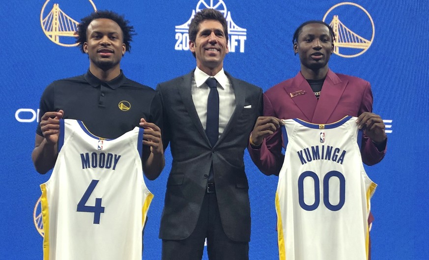 Golden State Warriors draft picks Moses Moody, left, Jonathan Kuminga, right, pose with general manager Bob Myers, center, and hold up their new jerseys during a news conference in San Francisco on Fr ...