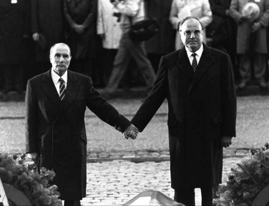 FILE- The Sept. 22, 1984 file photo shows then French President Francois Mitterrand and German Chancellor Helmut Kohl standing hand-in-hand as they listen to their respective national anthems during a ...