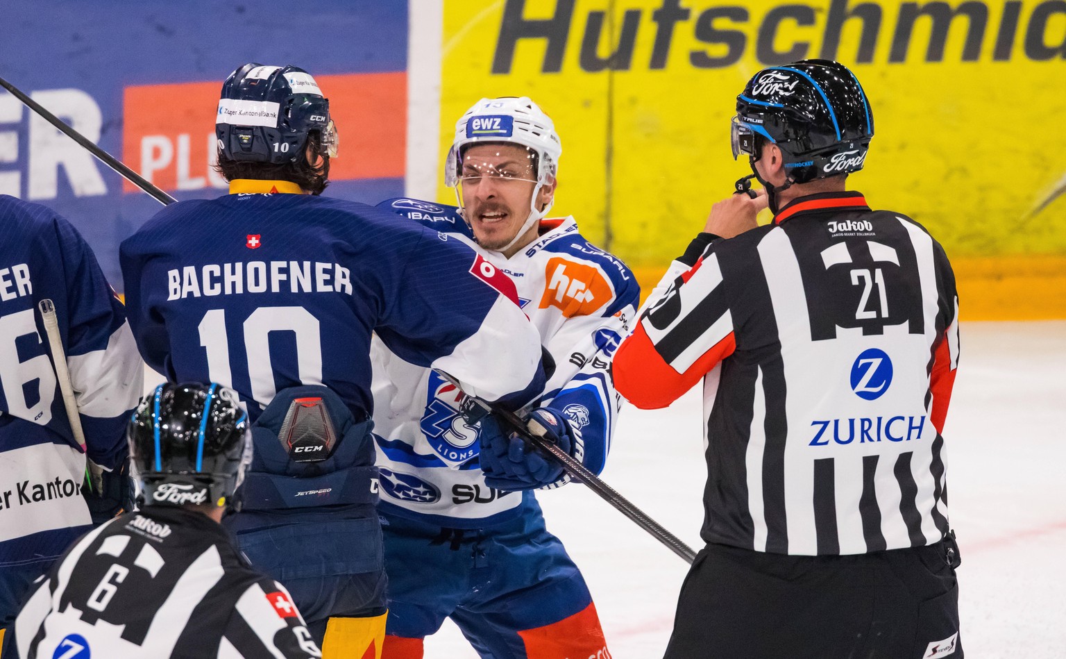 Zug, Schweiz - 23. April 2022: Auseinandersetzung zwischen dem Zürcher 13 Justin Sigrist und dem Zuger 10 Jerome Bachofner. Headschiedsrichter Miroslav Stolc ist bereits zur Stelle. Eishockey *** Zug, ...