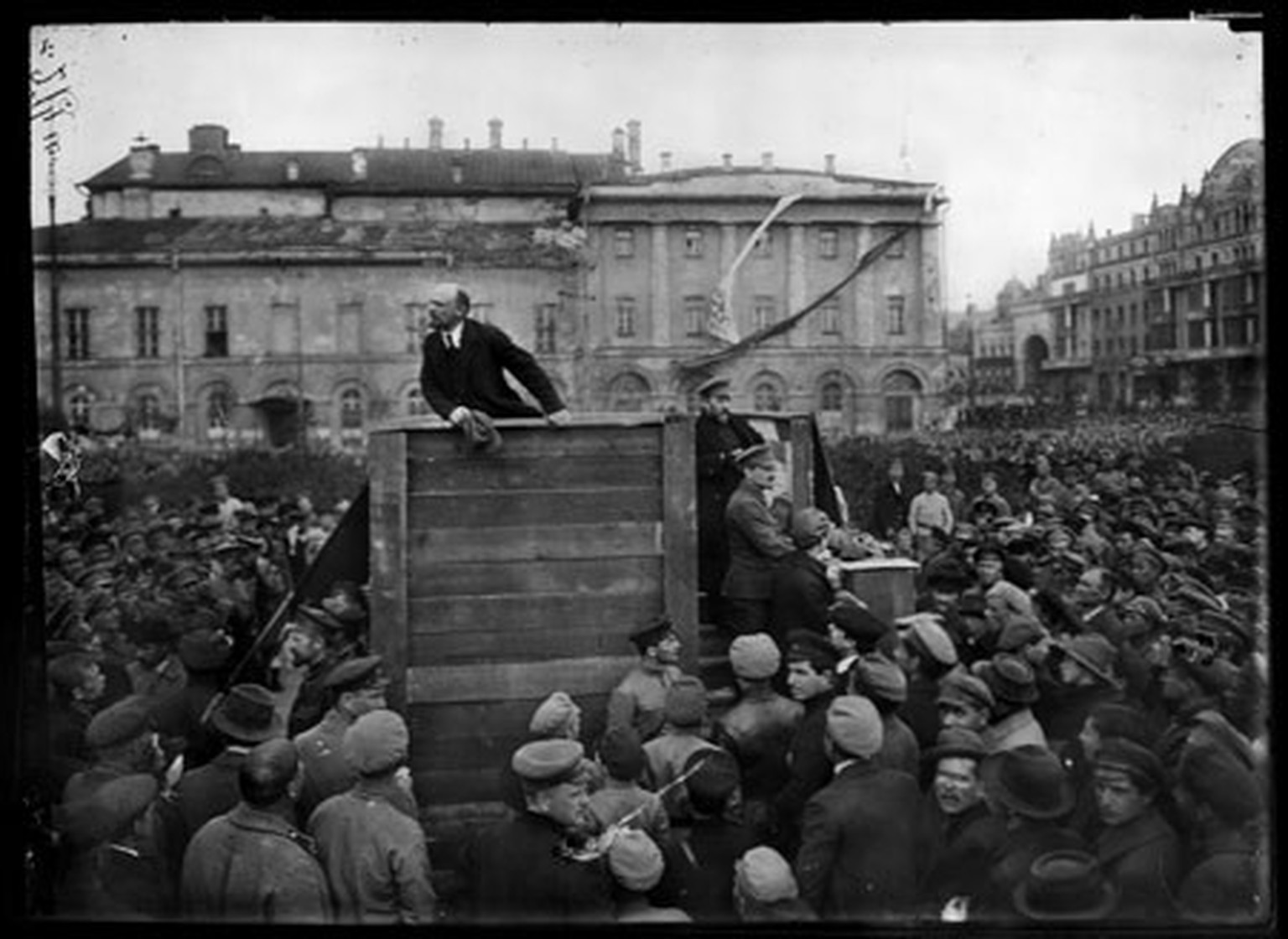 5. Mai 1920: Vor dem Bolschoitheater in Moskau hält Wladimir Iljitsch Lenin eine Rede vor Rotarmisten. Rechts auf der Treppe sind auf diesem Originalfoto sichtbar: Kamenew (oben) und Trotzki (unten).