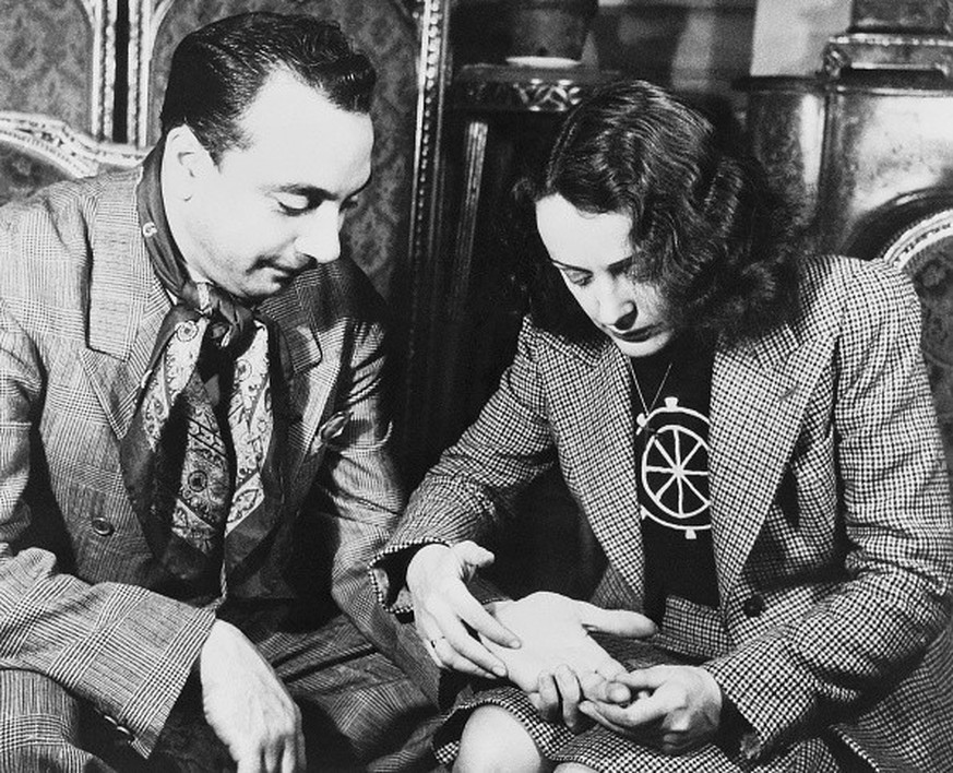 Belgian Jazz guitarist Django Reinhardt has his palm read by French singer Edith Piaf circa 1947 in Paris, France.