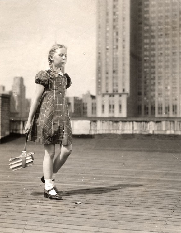 A schoolgirl carrying her schoolbooks in an urban setting, USA, circa 1930. (Photo by Vintage Images/Getty Images)