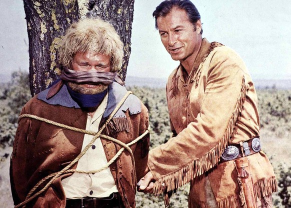 Ralf Wolter, Lex Barker Old Shatterhand (Lex Barker,r) hilft dem neugierigen Sam Hawkins (Ralf Wolter), der von Indianern geknebelt und an einen Marterpfahl gebunden wurde. 1965 UnitedArchives01369883 ...