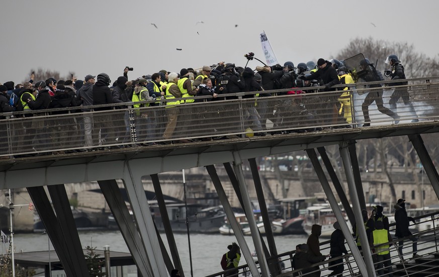 epa07264060 Protesters try to cross a bridge over the Seine river during a &#039;Yellow Vests&#039; protest in Paris, France, 05 January 2019. The so-called &#039;gilets jaunes&#039; (yellow vests) is ...