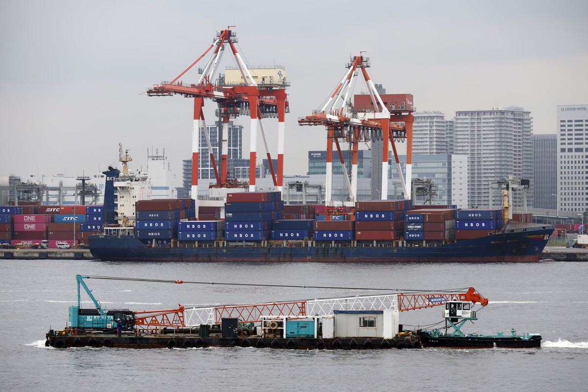epa12093334 A barge sails near a container ship at a port in Tokyo, Japan, 12 May 2025. According to the preliminary balance of payments report for FY2024 released by Japan's Finance Ministry, th ...