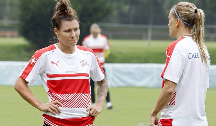 Switzerland&#039;s payers forward Ramona Bachmann, left, and midfielder Lara Dickenmann, right, speak together, during a training session of the national soccer team of Switzerland, at the Wilhelmina  ...