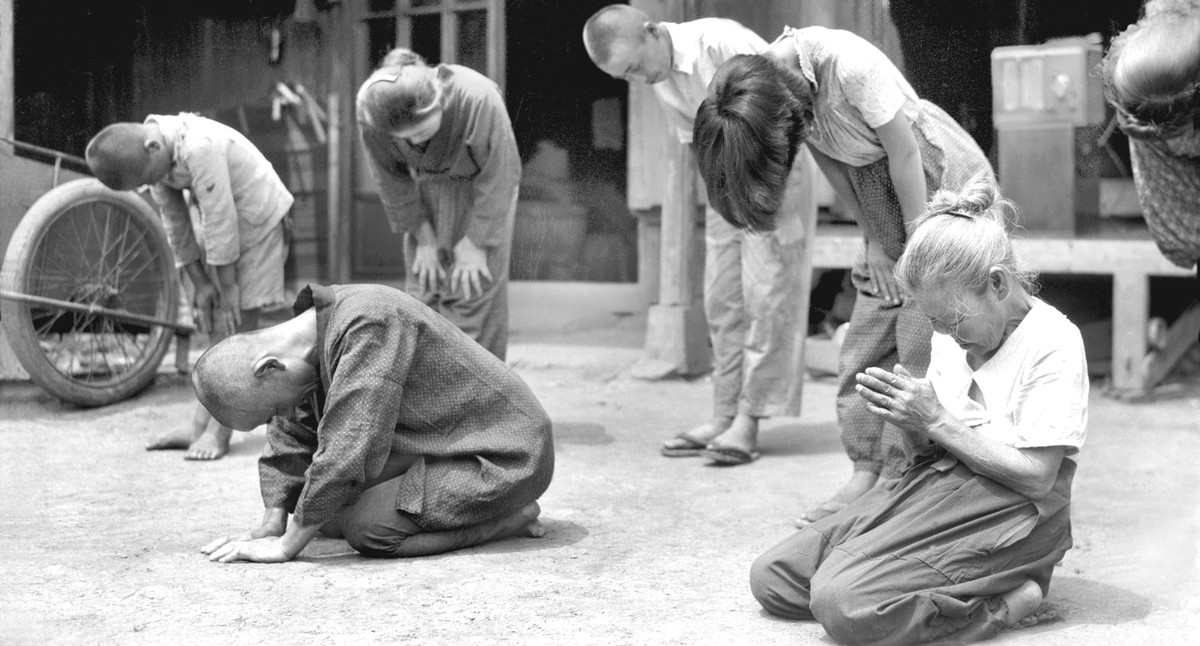 FILE - In this Aug. 15, 1945, file photo, Japanese people lower their head toward the Imperial Palace in Tokyo, as then Japan's Emperor Hirohito announces on radio that Japan was defeated in the  ...