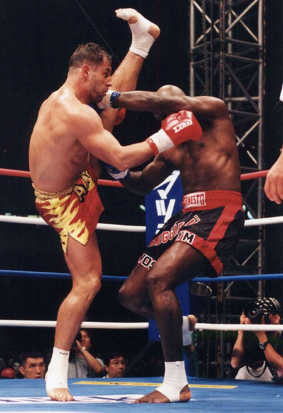 Swiss Andy Hug, left, charges Dutch Ernesto Hoost during their match of K-1 Grand Prix 1999 at the Tokyo Dome in Tokyo Sunday, December 5, 1999. Hug lost to Hoost by a decision. (KEYSTONE/AP Photo/Nik ...