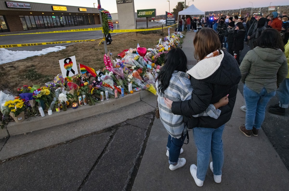 People gather around a memorial Sunday, Nov. 20, 2022, for the victims of Saturday's fatal shooting at Club Q in Colorado Springs, Colo. (Christian Murdock/The Gazette via AP)