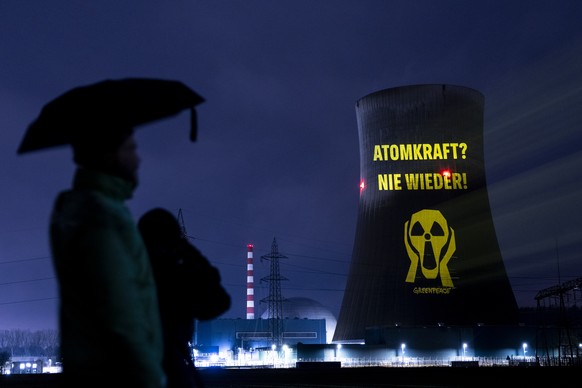 Greenpeace-Aktivisten projizieren einen Film und Parolen auf den Kuehlturm des AKW Goesgen am Mittwoch 28. Januar 2026 in Daeniken. Greenpeace kritisiert Sicherheitsluecken des Atomkraftwerks und die  ...