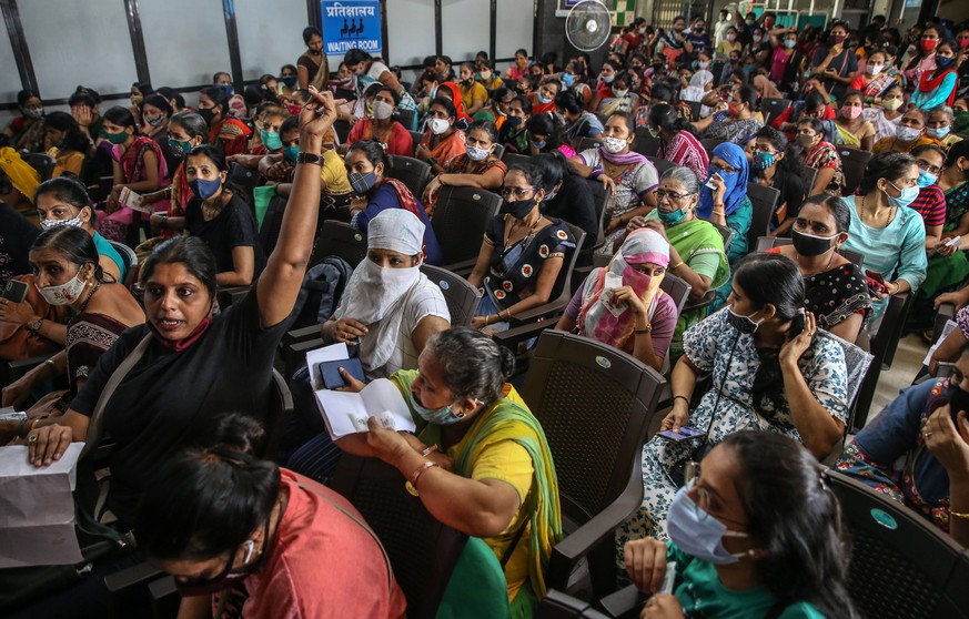 epa09473155 Indian women wait to receive a shot of the vaccine against COVID-19 during a special mass vaccination drive for women, in Mumbai, India, 17 September 2021. Brihanmumbai Municipal Corporati ...