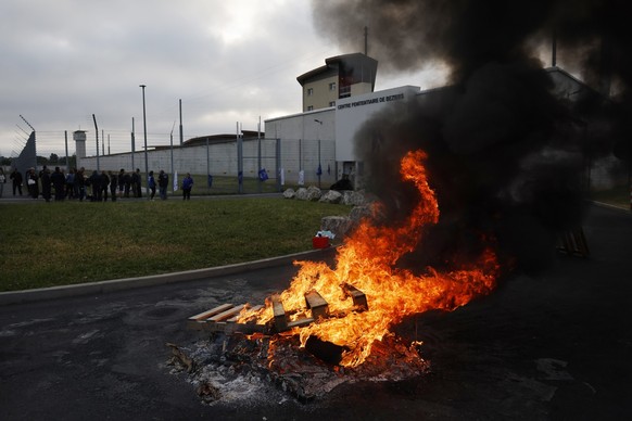 epa12916318 A fire is set outside the prison as penitentiary staff take part in a day of strike, in Beziers, southern France, 27 April 2026. Labor unions called for the strike over several work diffic ...