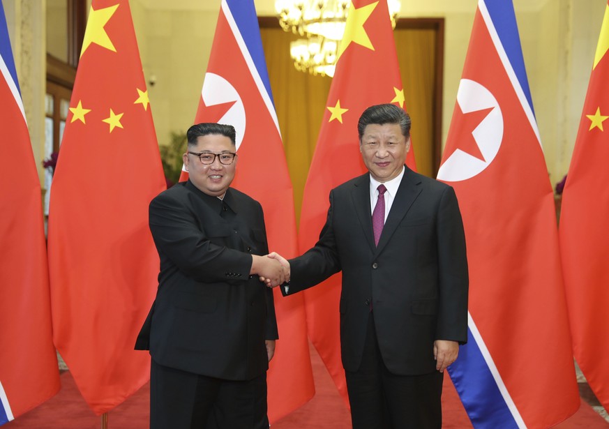 FILE- In this June 19, 2018, file photo provided by China&#039;s Xinhua News Agency, Chinese President Xi Jinping, right, shakes hands with North Korean leader Kim Jong Un, during a welcome ceremony a ...