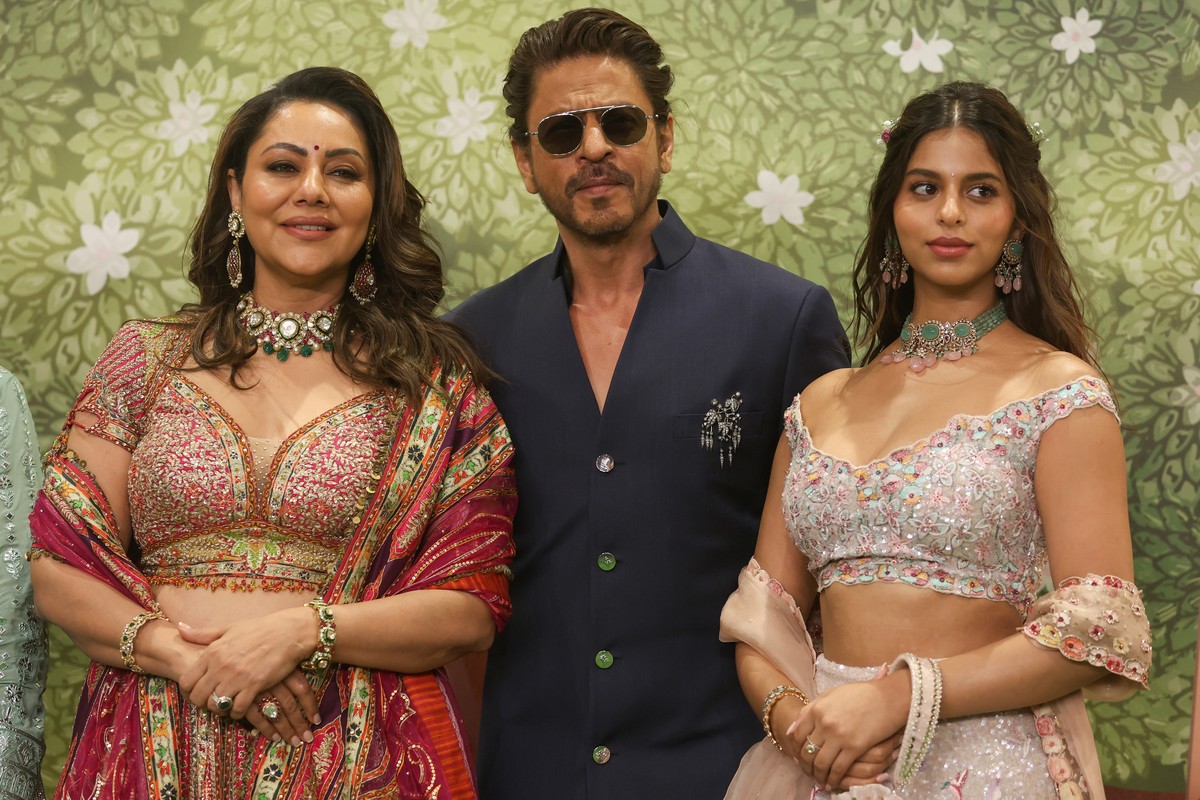 epaselect epa11476185 Indian actor Shah Rukh Khan (C) with his wife Gauri Khan (L) and daughter Suhana Khan (R) pose for photographs prior to attending the blessing ceremony of Anant Ambani, son of Re ...