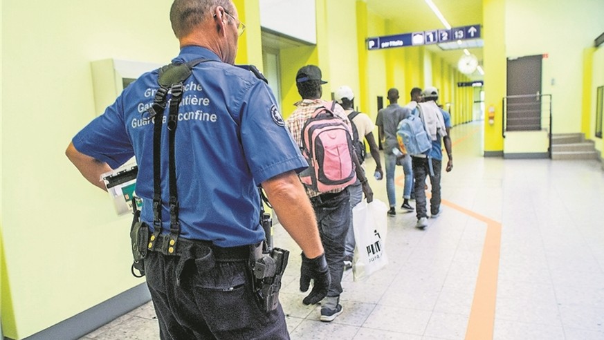 Ein Grenzwächter in Chiasso begleitet Flüchtlinge zur Personenkontrolle.