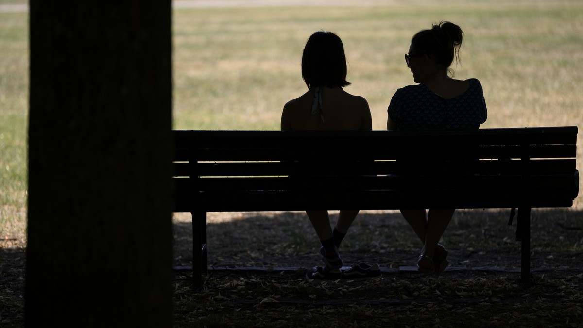 epa13058499 People sit on a bench in the shade in Milan Park during a heat wave in Lausanne, Switzerland, 23 June 2026. A heat wave is hitting Switzerland and is expected to last at least until 29 Jun ...