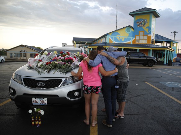 People pray by a car thought to belong to a victim of Thursday&#039;s boating accident before a candlelight vigil in the parking lot of Ride the Ducks Friday, July 20, 2018, in Branson, Mo. One of the ...