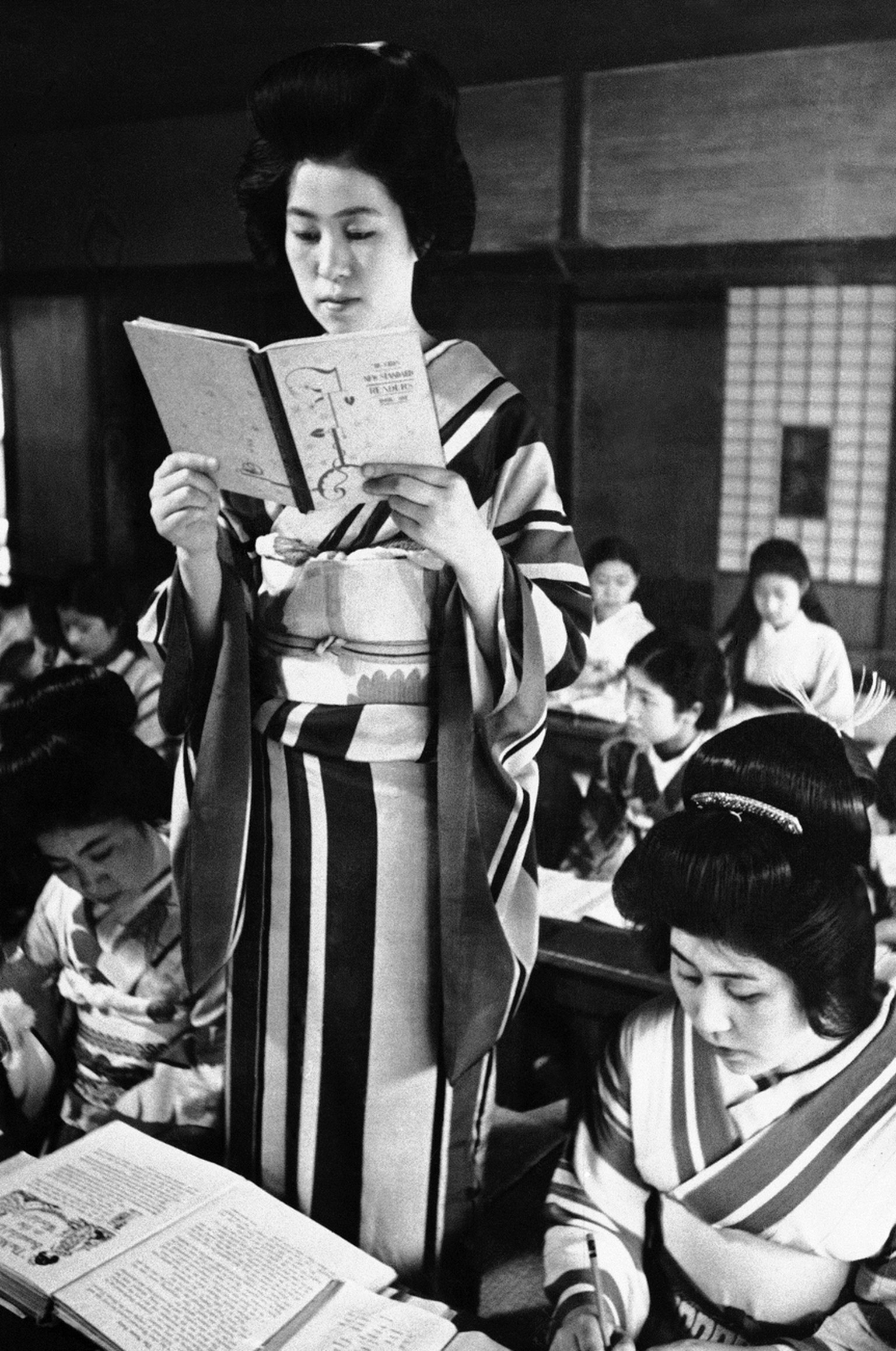 A Japanese geisha recites in her English class in school in July 1938. She hopes to be able to speak to Americans in their own language when they come to Tokyo in 1940 for the Olympic game. (AP Photo)