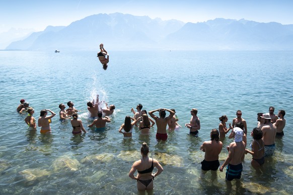 epaselect epa07735546 Visitors of the Fete des Vignerons (Winegrowers&#039; festival in French) cool off in the water of the Lake Geneva during sunny and warm weather in Vevey, Switzerland, 23 July 20 ...