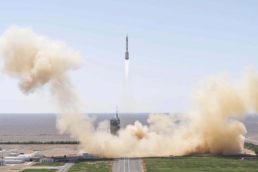 In this photo released by Xinhua News Agency, the Long March-2F carrier rocket carrying China's Shenzhou 14 spacecraft blasts off from the launch pad at the Jiuquan Satellite Launch Center in Jiuquan, ...