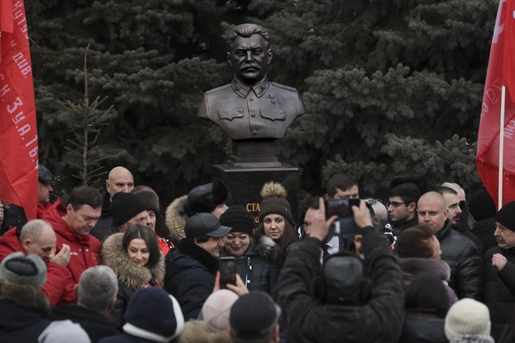 People take pictures in front of the bust of Soviet leader Josef Stalin, after an inauguration of busts of him and other Marshal of the Soviet Union Georgy Zhukov and Aleksandr Vasilevsky in the territory…