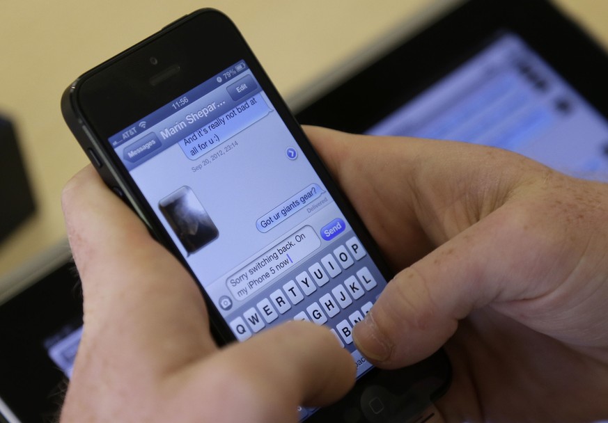 A costumer sets up an iPhone 5 at an Apple store in San Francisco, Friday, Sept. 21, 2012. (AP Photo/Marcio Jose Sanchez)