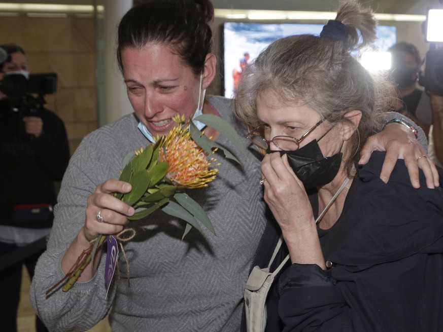 A woman, right, is embraced by a loved-one after arriving on a flight from Los Angeles at Sydney Airport as Australia opened its borders for the first time in 19 months in Sydney, Monday, Nov. 1, 2021 ...