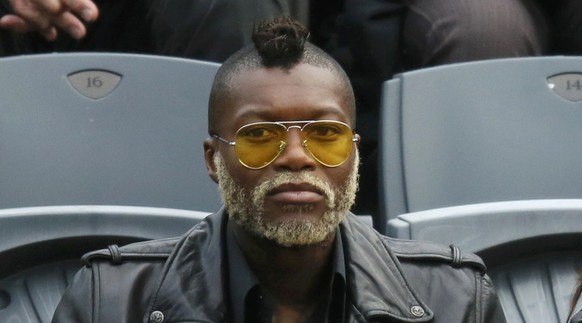 Soccer player Djibril Cisse (L) watches the men&#039;s singles match between Roger Federer of Switzerland and Gael Monfils of France at the French Open tennis tournament at the Roland Garros stadium i ...