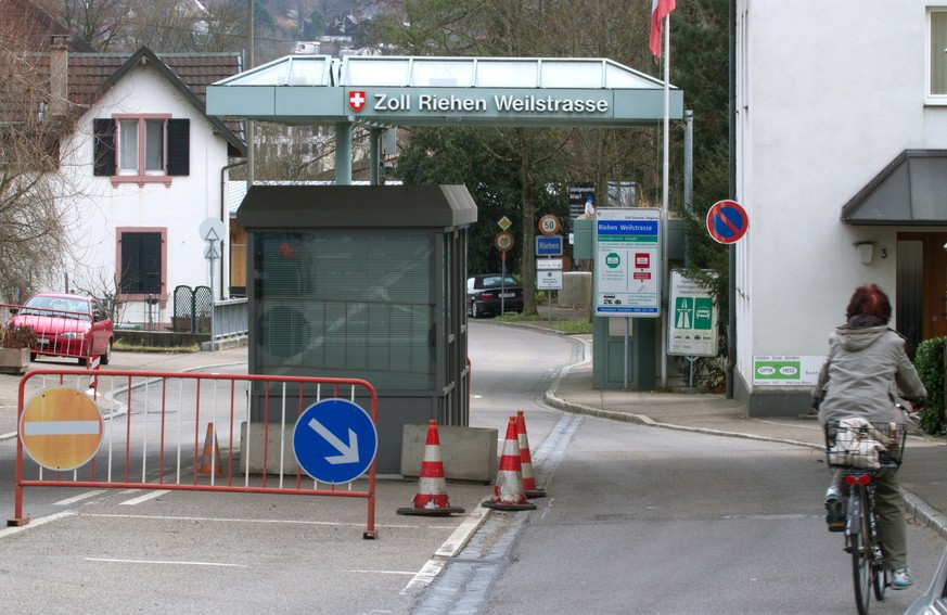 WEIL AM RHEIN, GERMANY - FEBRUARY 10: A woman on a bicycle enters into Switzerland from Germany at the border crossing on February 10, 2014 at Weil am Rhein Ost weilstrasse, Germany. Swiss citizens vo ...