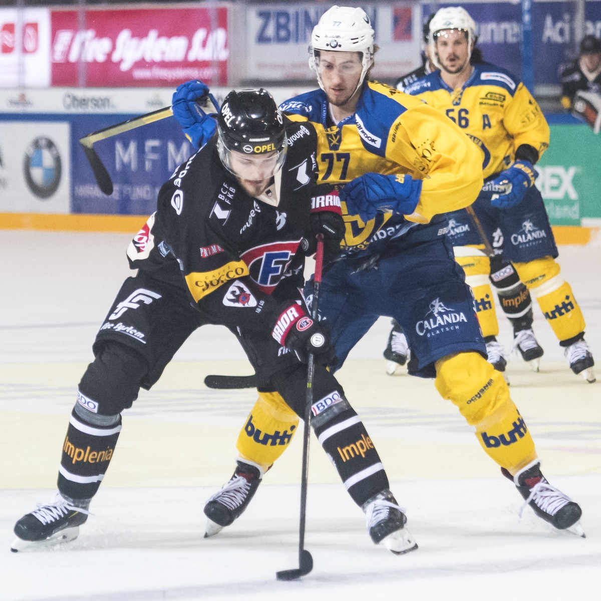 L'attaquant fribourgeois Charles Bertrand, gauche, lutte pour le puck avec le defenseur davosiens Thierry Bader, droite, lors de la rencontre du championnat suisse de hockey sur glace de National ...