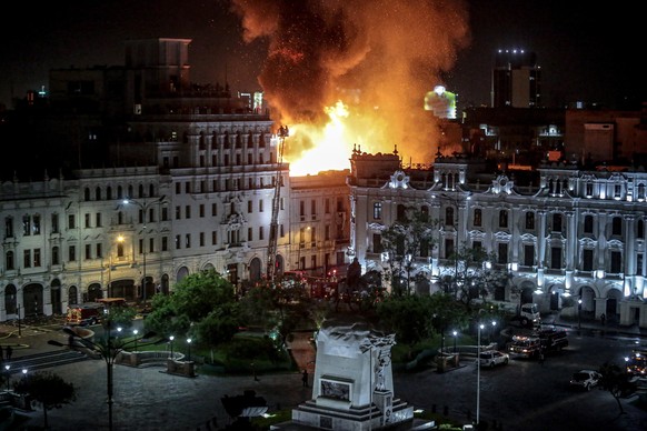 epa10416867 A fire burns in a mansion, as seen from the historic Plaza San Martin, where anti-government protestors clashed with police on the same day, in Lima, Peru, 19 January 2023. EPA/STR