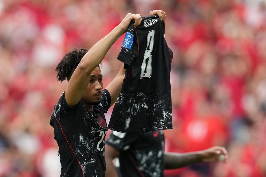 Canada's Nathan Saliba holds up the jersey of injured teammate Ismael Kone after scoring his side's fourth goal during the World Cup Group B soccer match against Qatar in Vancouver, British  ...