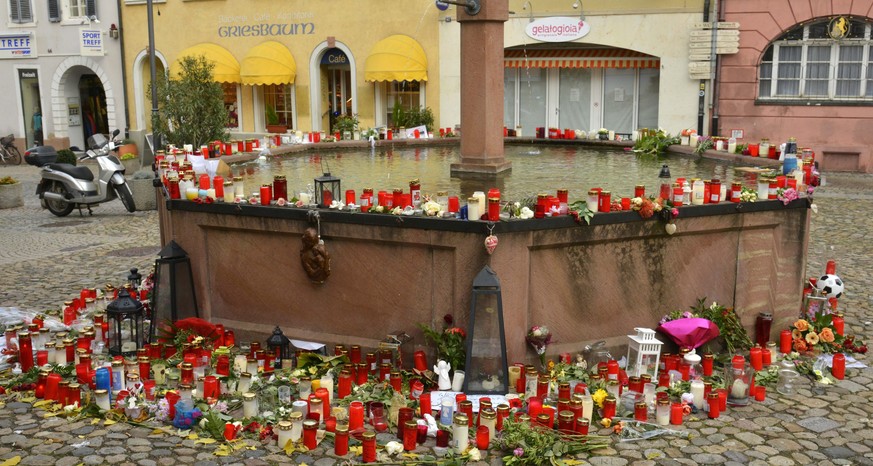 epa05634773 A well in a town square covered in flowers and letters of remembrance in honour of a recently murdered jogger in Endingen, Germany, 17 November 2016. Police investigations are underway aft ...