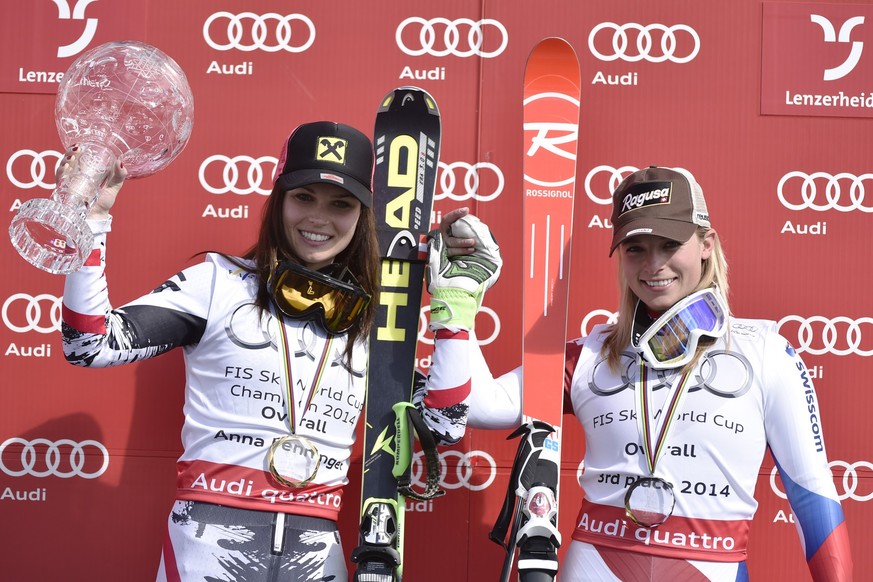 Austria's Anna Fenninger, left, poses with the World Cup overall trophy, together with Switzerland's Lara Gut after at the FIS Alpine Skiing World Cup finals in Parpan-Lenzerheide, Switzerla ...