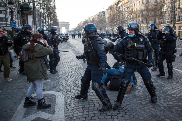 epa09750521 French police arrest demonstrators on the Champs Elysees as participants in a so-called &#039;Freedom Convoy&#039; are trying to block the traffic, in Paris, France, 12 February 2022. Pari ...