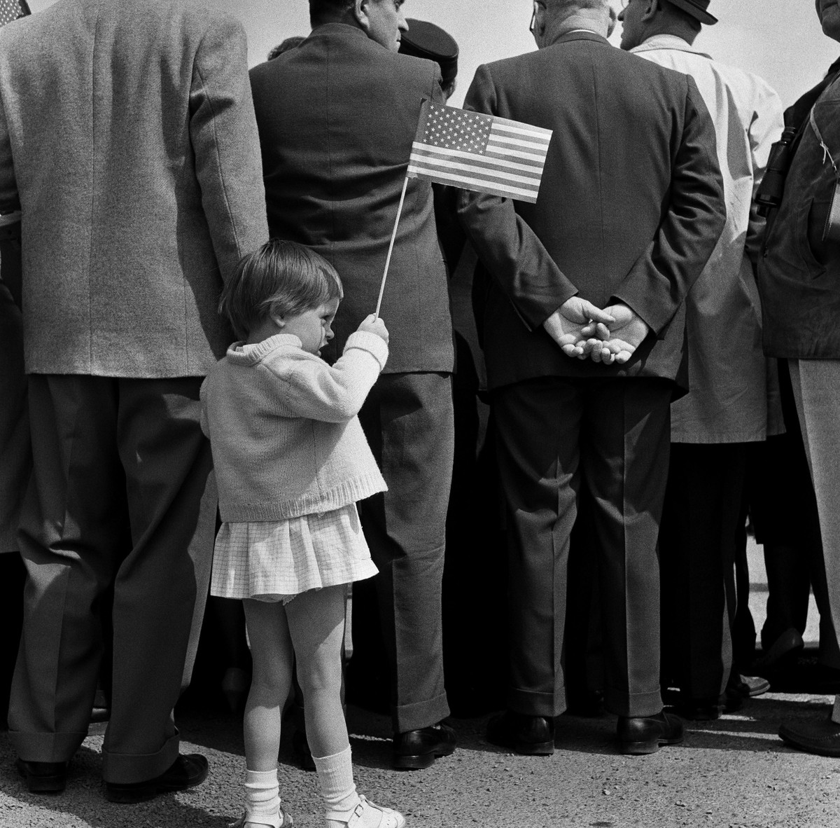 BERLIN - JUNE 26, 1963: A young girl holds up an American flag at the Rudolph Wilde Platz for President John F. Kennedy's famous "Ich bin ein Berliner" speech on June 26, 1963, in Berli ...