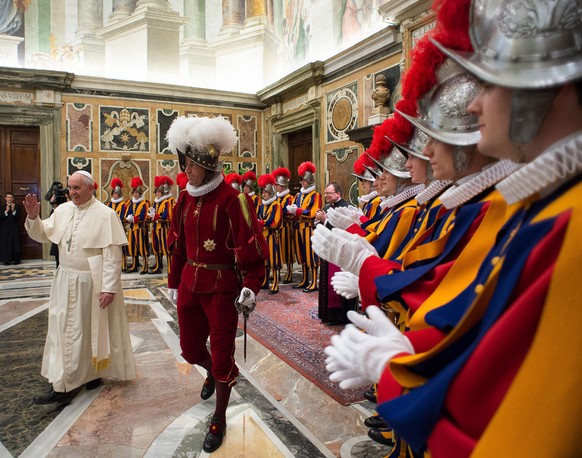 In this photo taken Monday, May 5, 2014, and provided by the Vatican newspaper L&#039;Osservatore Romano, Pope Francis, flanked by Swiss Guards Commander Daniel Rudolf Anrig, greets new Swiss Guards t ...