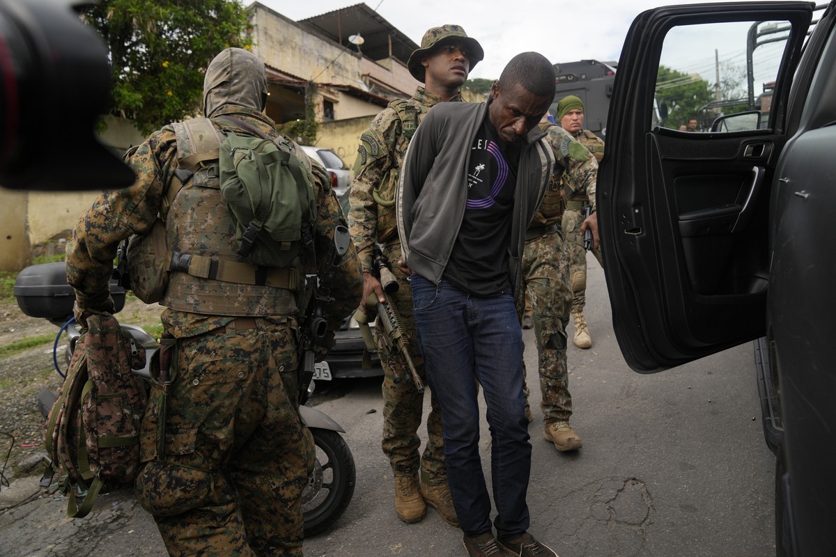 A man is detained by special forces military police for alleged drug trafficking during a police operation in the Vila Cruzeiro favela of Rio de Janeiro, Brazil, early Friday, Feb. 11, 2022. (AP Photo ...
