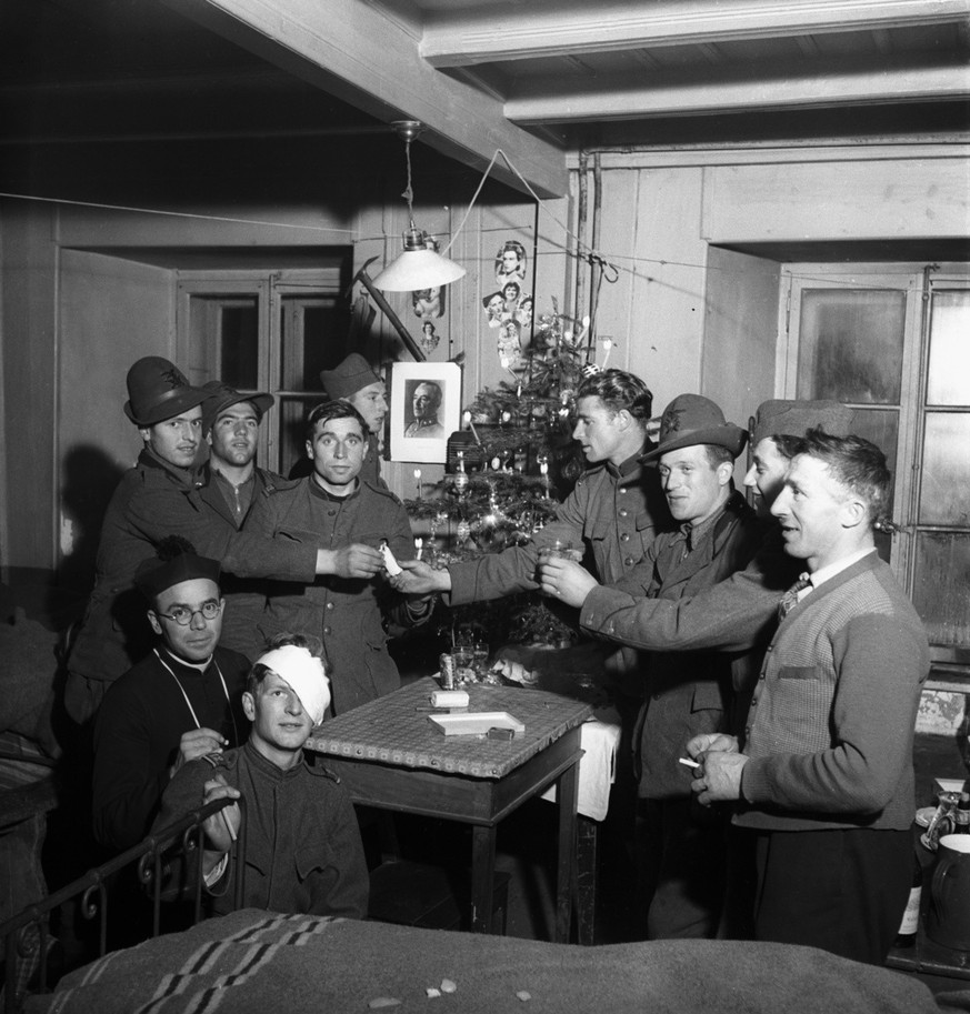 Soldiers of the Swiss Army on active duty celebrate Christmas together with Italian border guards and an Italian priest, pictured on December 24, 1939, during the war on Grand St. Bernard mountain pas ...