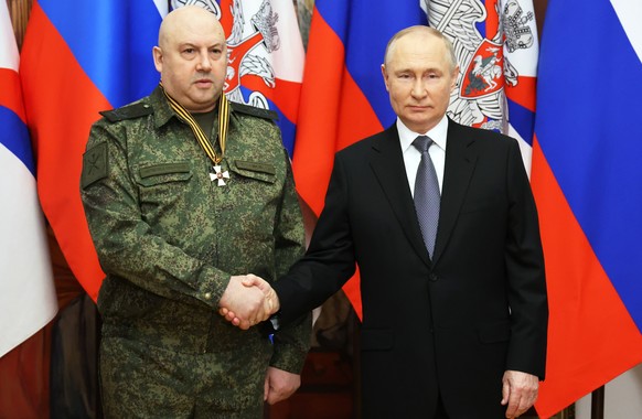 epa10384013 Russian President Vladimir Putin (R) shakes hands with the commander of the Russian military operation in Ukraine, General Sergei Surovikin, awarded the Order of Saint George of the Third C...