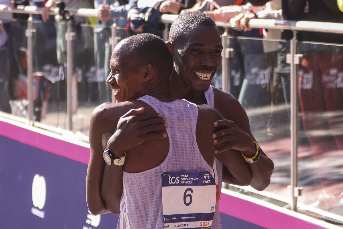 epa12499380 Alexander Mutiso of Kenya (L) and Benson Kipruto of Kenya (R) hug after crossing the finish line to place first and second in the 2025 TCS New York City Marathon Pro Men's Open Divisi ...