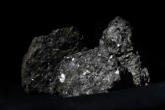 In this picture taken on Tuesday, March 28, 2017, pieces of lithium sparkle in ore sample placed on a table in Prague, Czech Republic. Recent explorations confirmed large deposits of lithium near the  ...